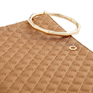 Close-up of caramel diamond quilting and the segmented gold bracelet handle