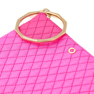 Close-up of vivid pink diamond quilting and the segmented gold bracelet handle