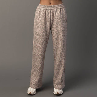 Leopard print pants worn by a person on a gray background