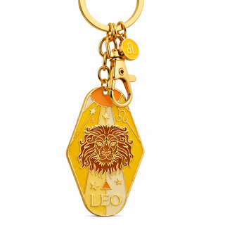 Gold-tone metal keychain featuring a hexagonal pendant with an engraved lion face, stars, and the word 'LEO', plus a small circular charm marked with the Leo zodiac symbol, on a white background.
