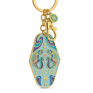 A gold-tone metal keychain featuring a coffin-shaped Pisces zodiac charm with turquoise, purple, and pink enamel details, shown on a plain white background.