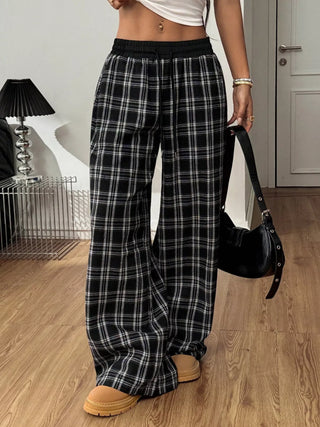 Woman wearing plaid wide-leg pants with elastic waistband, front view