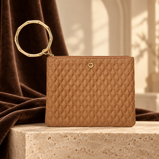 Caramel quilted Big O bracelet pouch with gold circular handle on cream stone