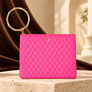 Tickled Pink quilted Big O bracelet pouch with gold circular handle on cream stone