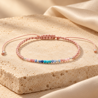 Om Namaste healing stone bracelet arranged on warm cream stone and silk