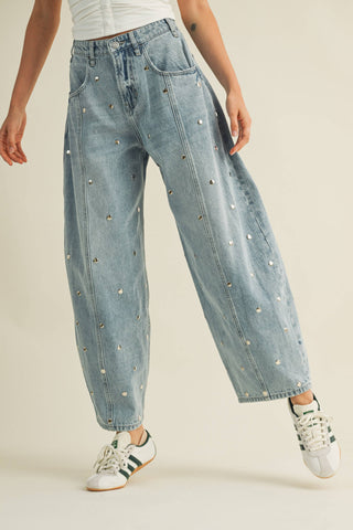 Light-wash barrel leg jeans with stud detailing styled casually with sneakers