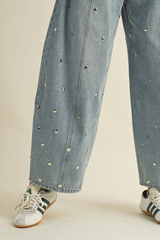 Full-length styling view of women’s studded barrel jeans in a light denim wash