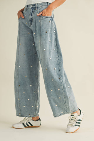 Women’s light-wash studded barrel jeans shown from the side with tapered ankle shape