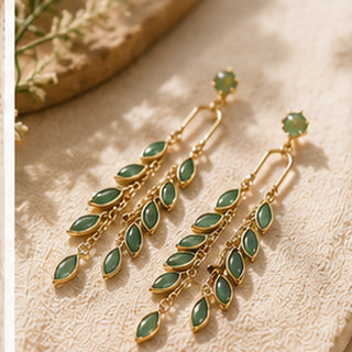 Verdant Cascade green cat-eye stone earrings styled on cream fabric